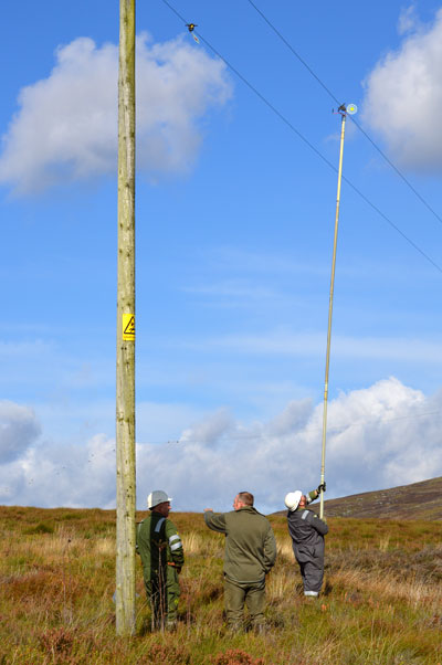 Scottish Power crew and Simon Lester fitting line markers to power lines at Langholm.